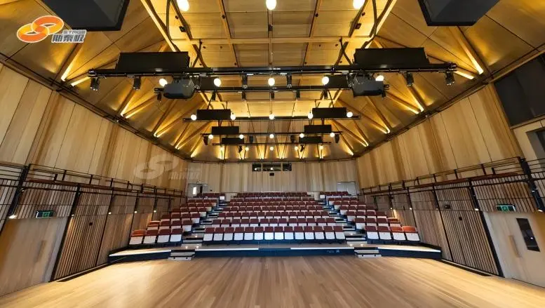 Overstage machinery system installed in a modern theater fly tower, showing winches, fixed trussing and rigging infrastructure above the stage. Overstage machinery system installed in a modern theater fly tower, showing winches, fixed trussing and rigging infrastructure above the stage.